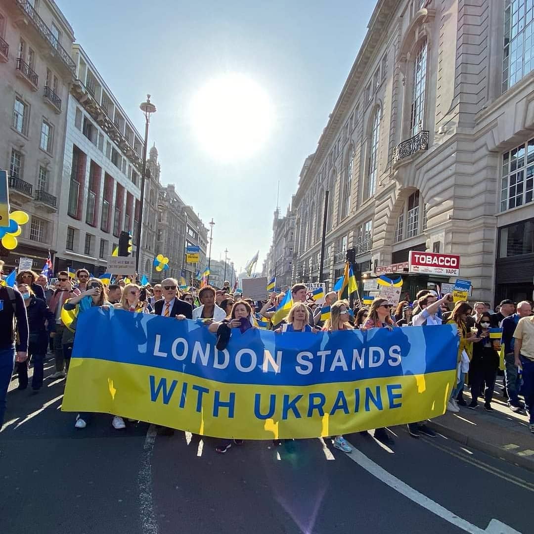 Val_Voshchevska's tweet photo. As I walked down Piccadilly holding 👇 banner (woman in orange) I couldn't stop thinking - while I appreciate solidarity, why is it so hard for me to get my best friend to London. The anxiety of waiting is excruciating. Please @pritipatel, easy restrictions on people fleeing war. https://t.co/bpfm4hsXH2