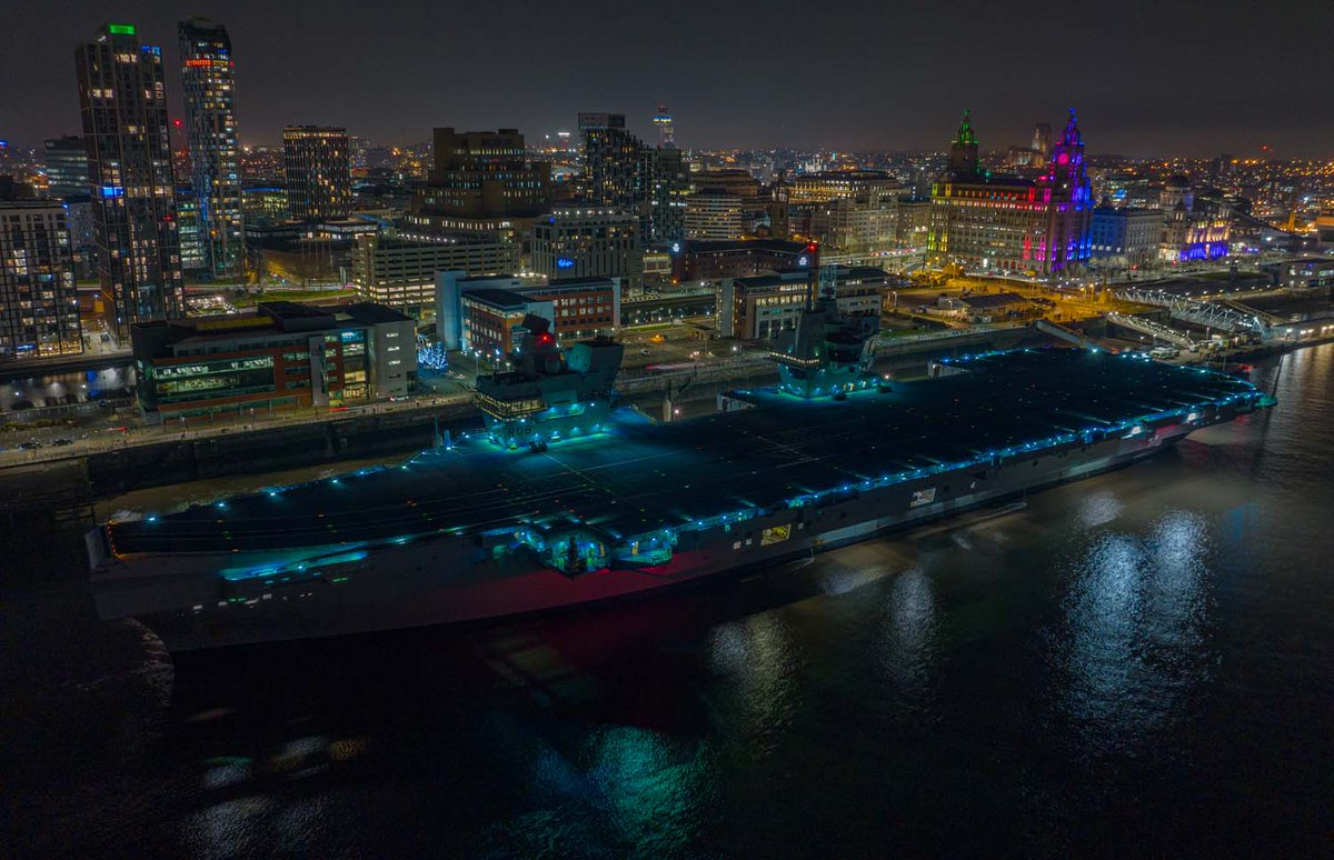 HMS Queen Elizabeth alongside in Liverpool with the Liver Building in the background at night