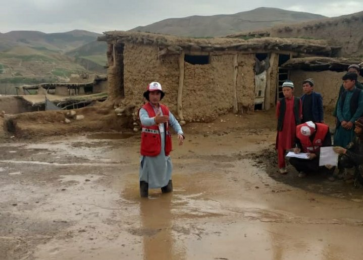 Afghan Red Crescent volunteers wade through mud and damaging flash floods to help families in Sar-e-Pol province, northern Afghanistan.