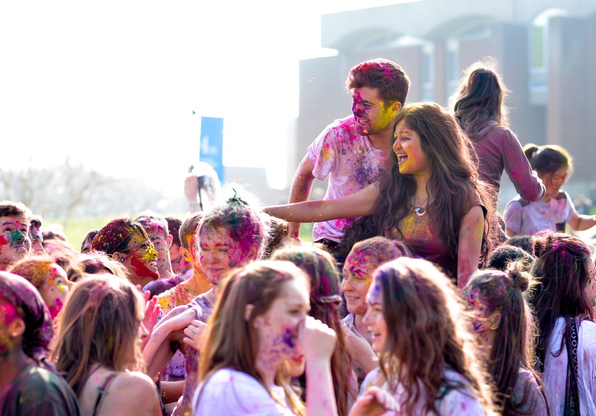 Students splashed with colourful powder celebrating Holi festival on campus