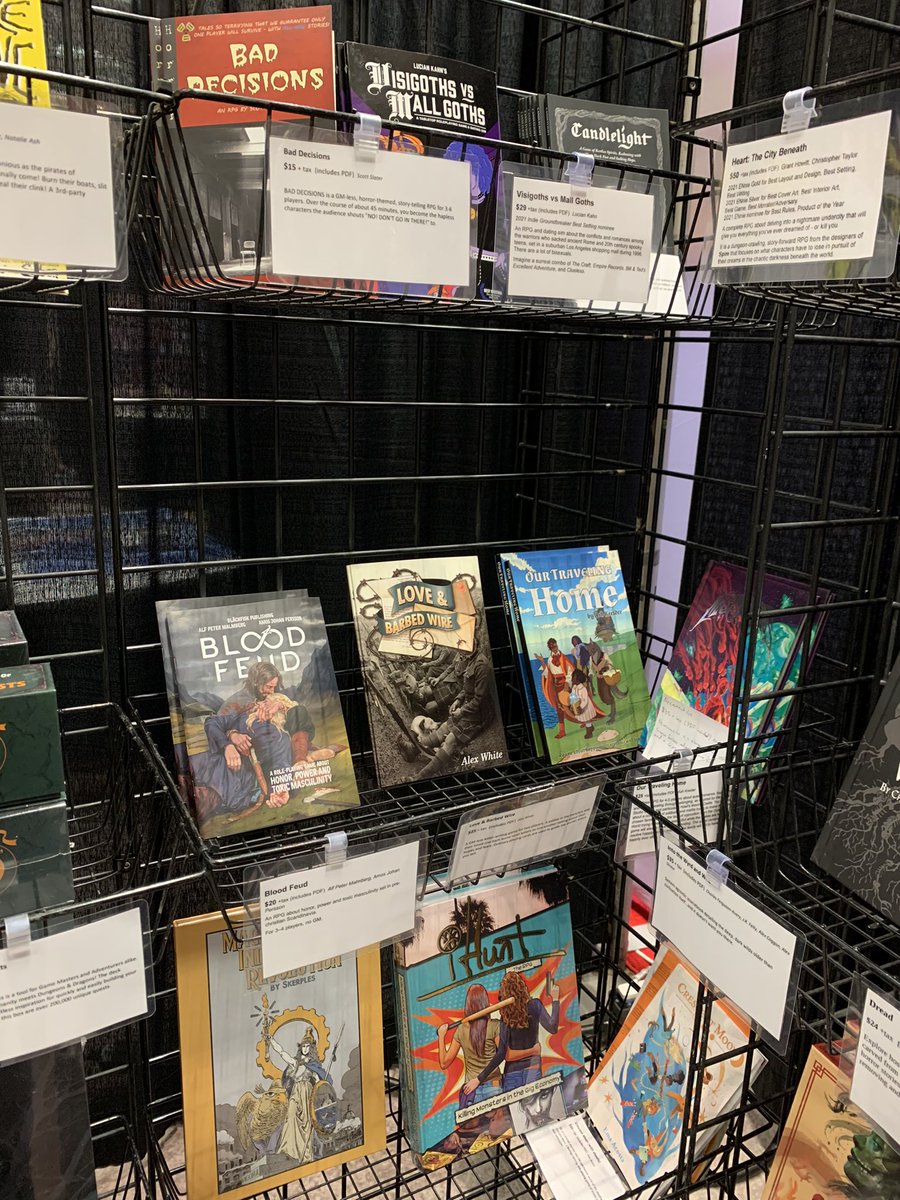 We’ve rearranged a bit for day two, so I have half a table and another shelf for y’all! Including Haunted West by @Darker_Hue, Visigoths vs Mall Goths by @oh_theogony, Love & Barbed Wire by @NAlexWhite, and so very many more!