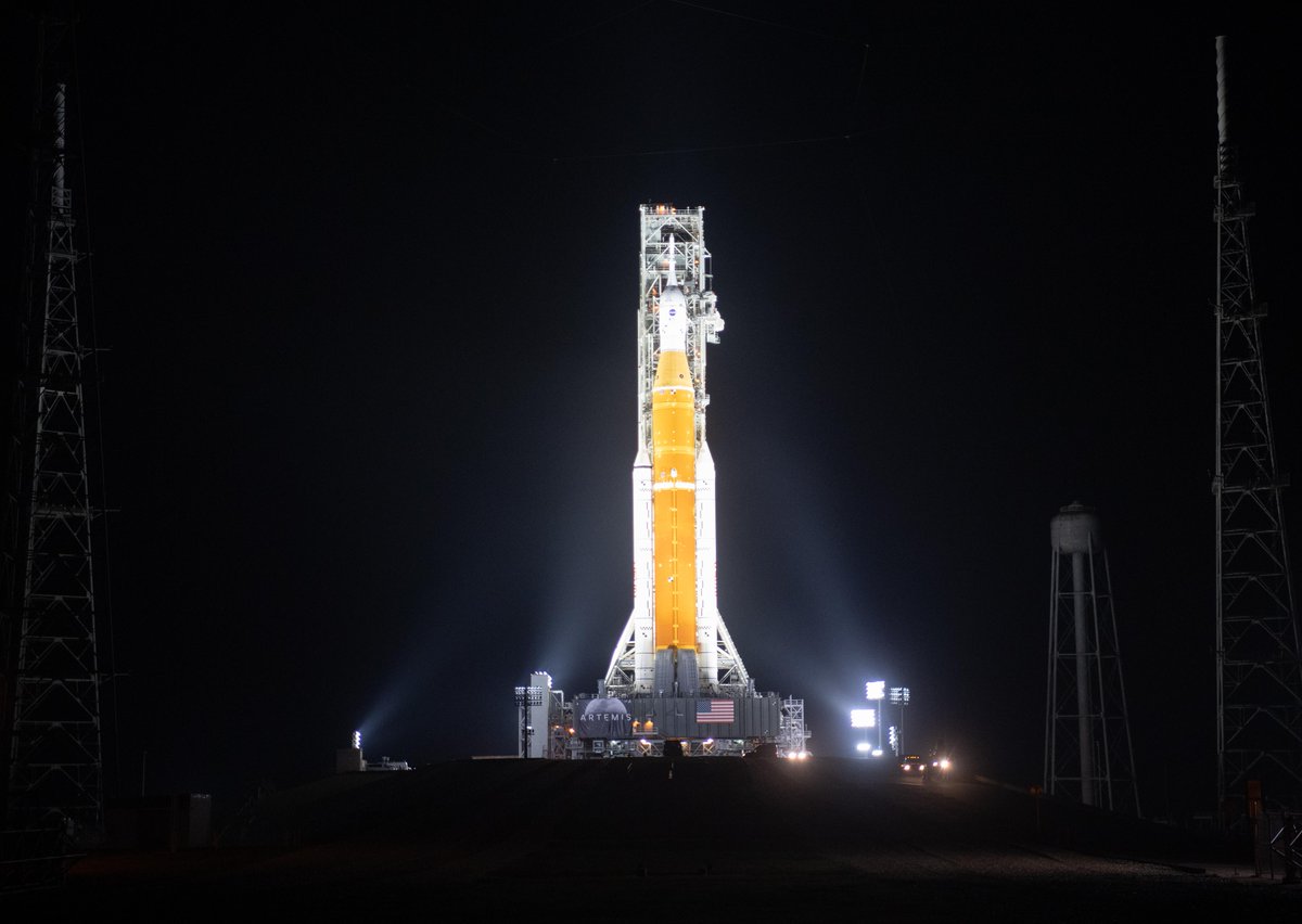 NASA’s Space Launch System rocket with the Orion spacecraft aboard is seen illuminated by spotlights atop a mobile launcher at Launch Complex 39B.