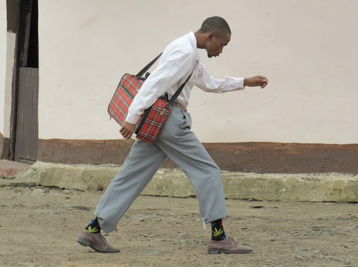A rare pic of a Makerere student moving back to the freedom square to pick the looted chicken that he kept in the grass