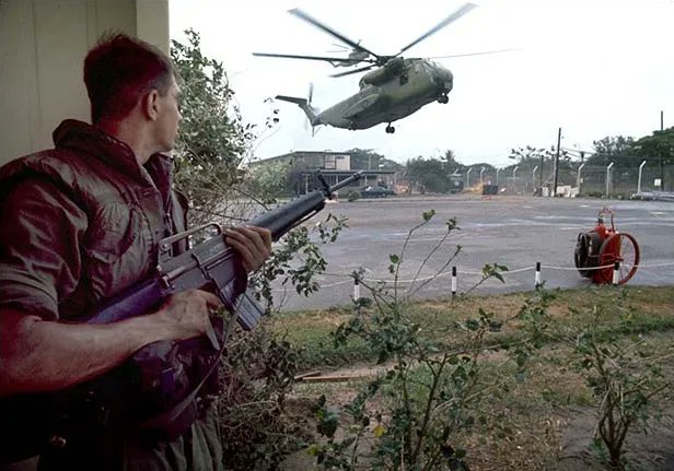 libraryofwar's tweet photo. A Marine provides security as helicopters land at the DAO Compound Vietnam #vietnam #vietnamwar #history #libraryofwar https://t.co/kjrjgqaTRf