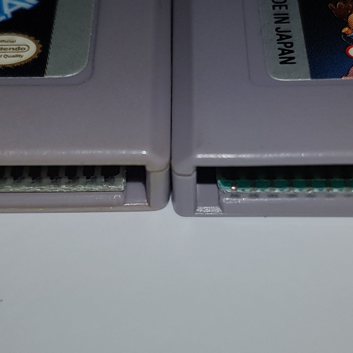 bakapawn's tweet photo. En esta otra foto podéis ver a simple vista y sin necesidad de abrir el cartucho, los acabados usados en las placas de una repro y un original. En la izquierda (repro) se puede apreciar que el corte de la placa acaba en ángulo de 90º, en la derecha se ve más redondeado (original) https://t.co/jvy1Yw5qXy