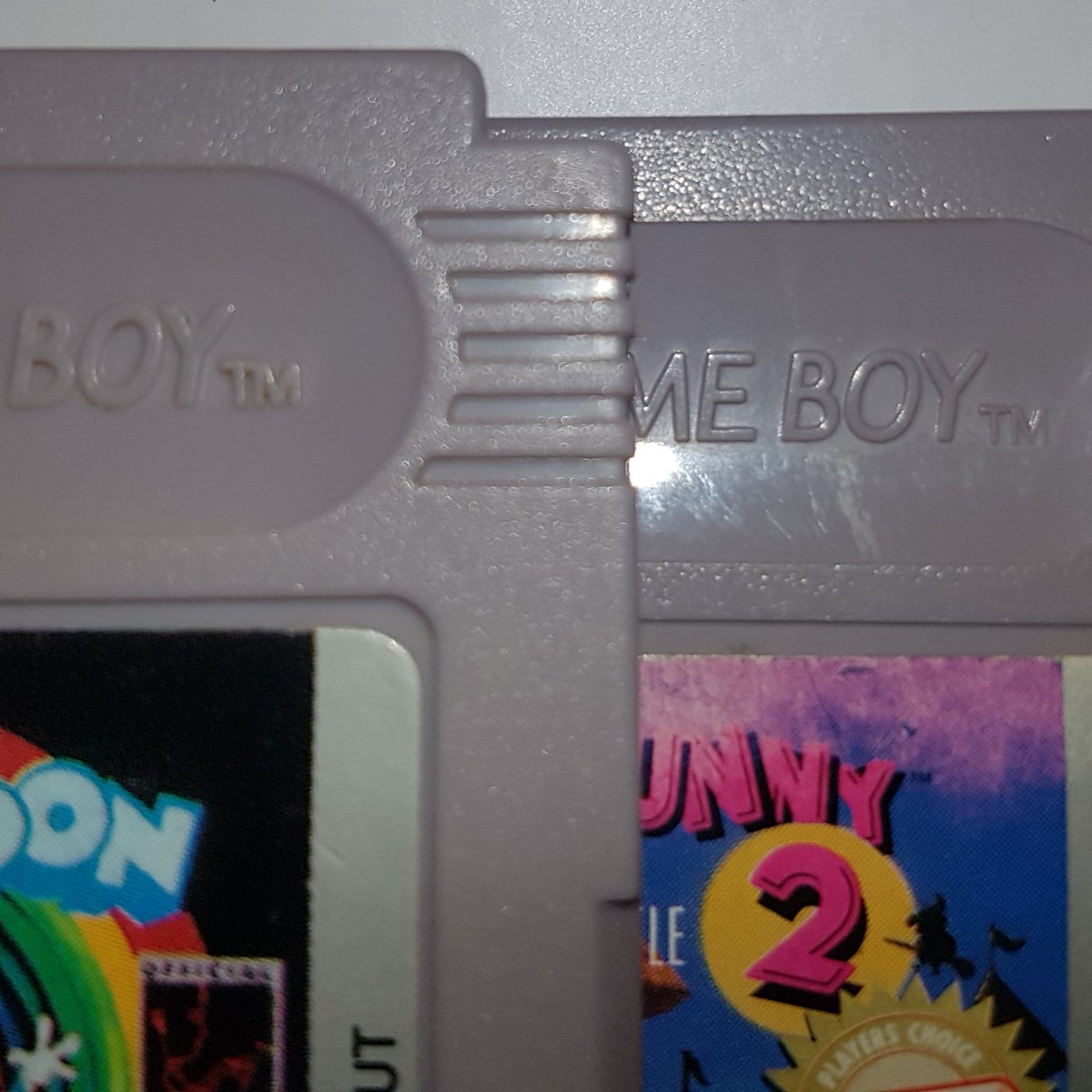 bakapawn's tweet photo. En el plástico exterior del cartucho también se pueden ver más diferencias. Las letras "MADE IN JAPAN" y "PAT PEND." están grabadas más profundamente en el cartucho de abajo (repro) que en el de arriba (original). Las letras "GAME BOY TM" son más vastas en la izquierda (repro) https://t.co/YYZtdGrWm9