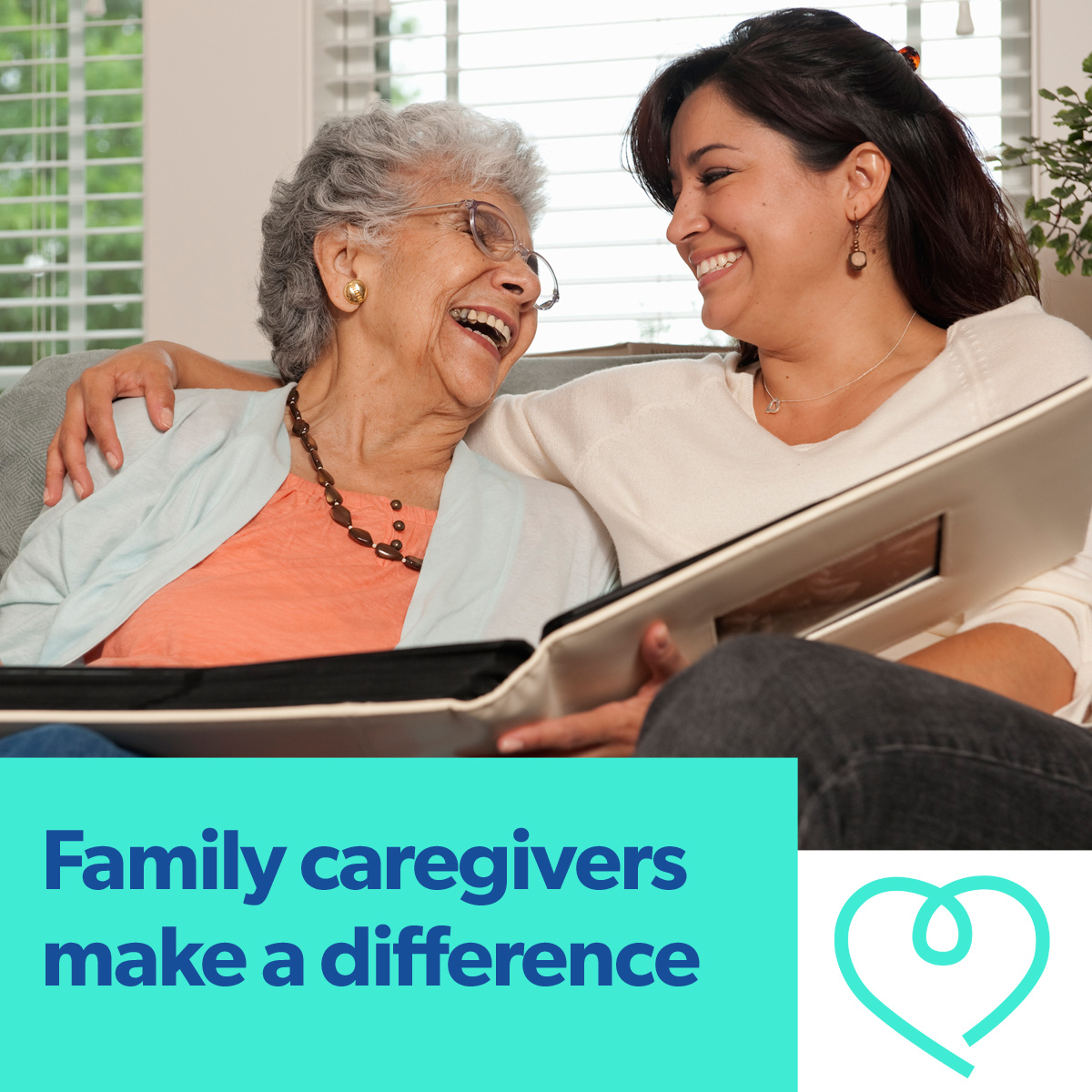 An elderly woman shares a photo album with a younger woman who is her family caregiver. The caregiver has her arm around the older woman, and the two are laughing together. Image headline reads "Family caregivers make a difference."
