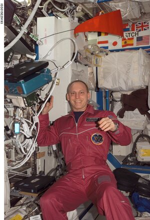 Astro_Clay's tweet photo. Just to be clear, here's my "red" flight suit that was custom made for me on my #ISSExp15 flight back in 2007. Note the "scarlet" Nebraska banner flying above my head..., that's the red I wanted. https://t.co/4gSi56VsE3