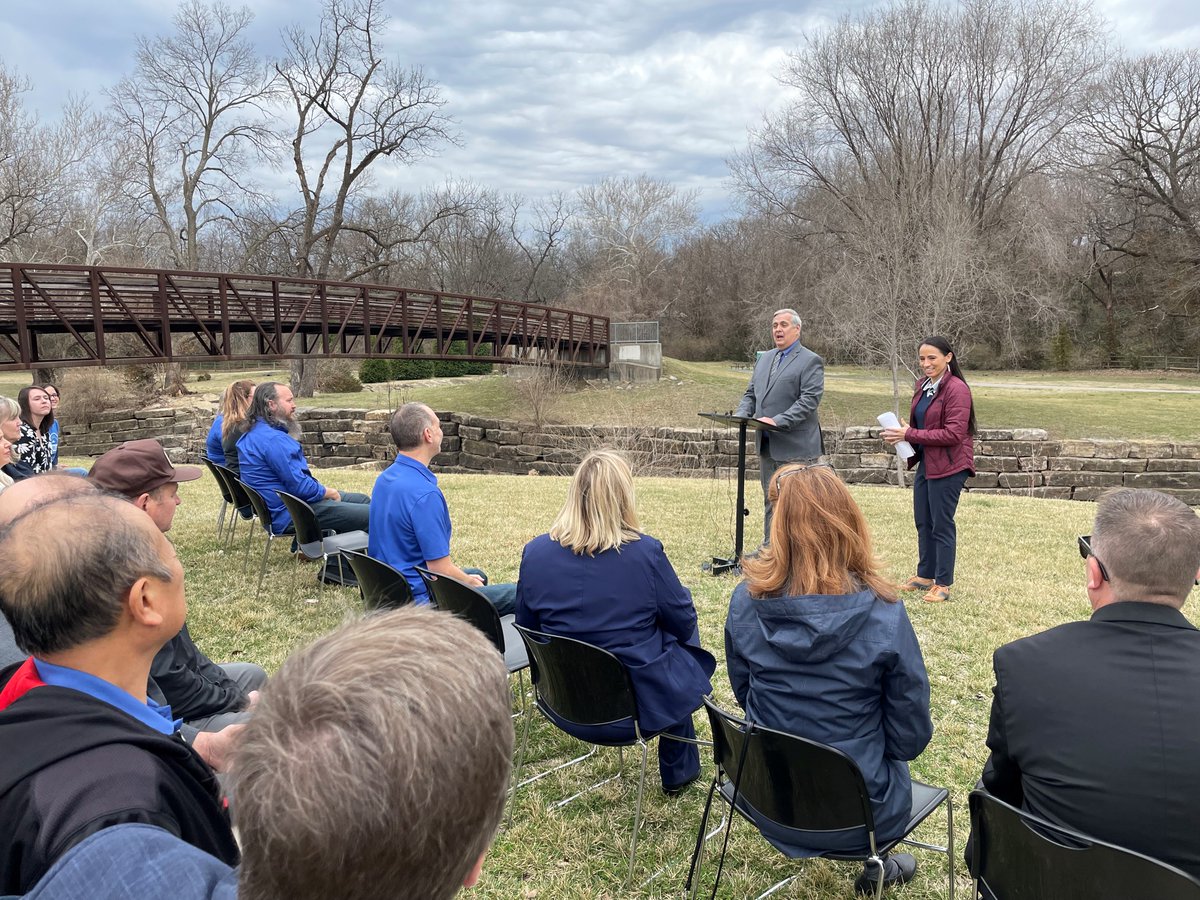 Representative Sharice Davids standing next Merriam Mayor Bob Pape speaking to a small crowd outdoors in Merriam, Kansas. 
