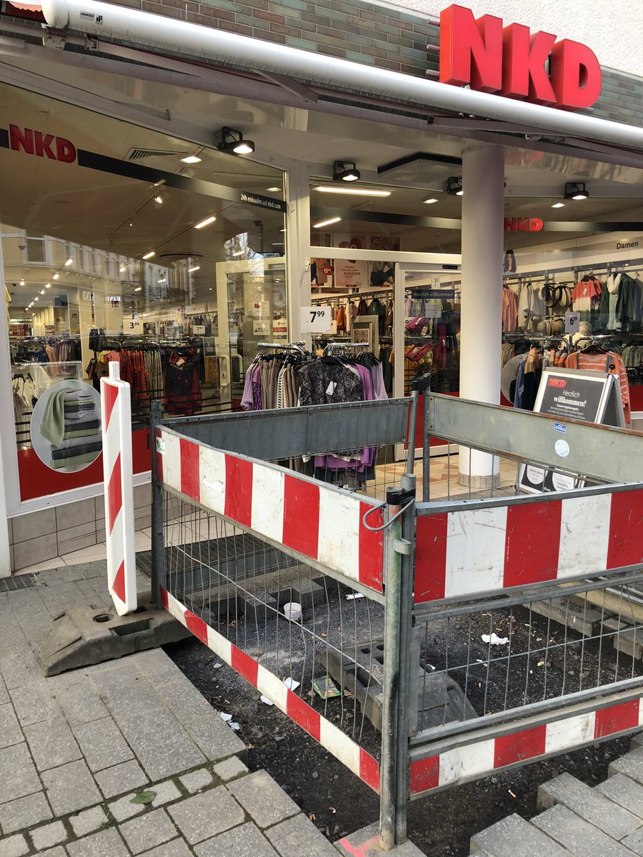 Vor dem NKD ein rot-weißer Bauzaun um ein Loch im Bürgersteig.