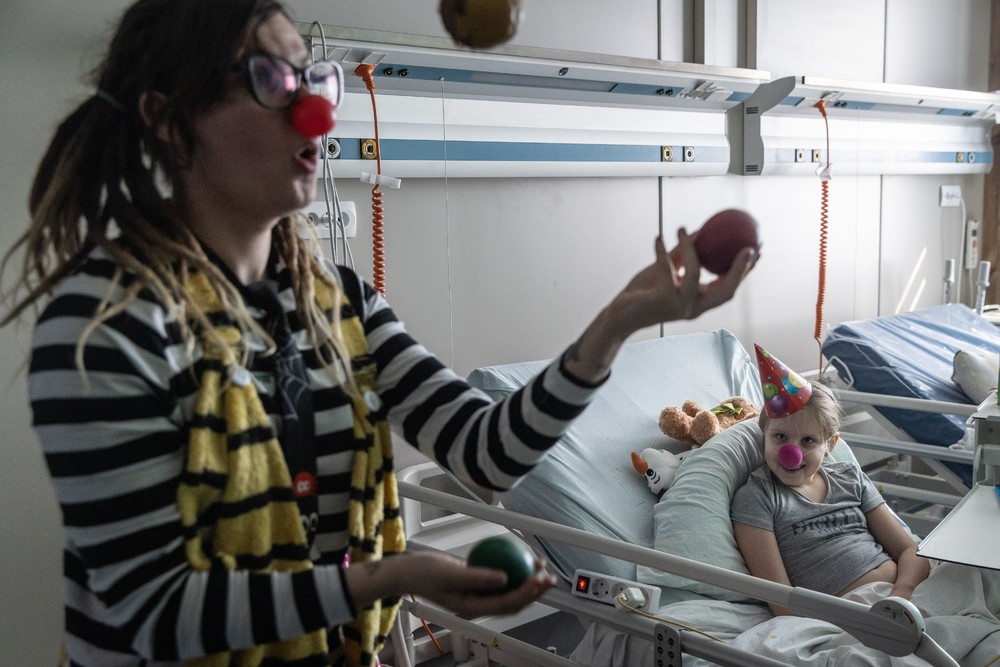 phjournalism's tweet photo. 6 year-old Milana who is recovering from leg injuries sustained after a Russian rocket hit her house on February 28, killing her mother, reacts to volunteers dressed as clowns at a children's hospital.
#Kyiv #Ukraine March 19, 2022 
📸 @cmcgrath_photo  @GettyImages https://t.co/BTVQDYDjkp