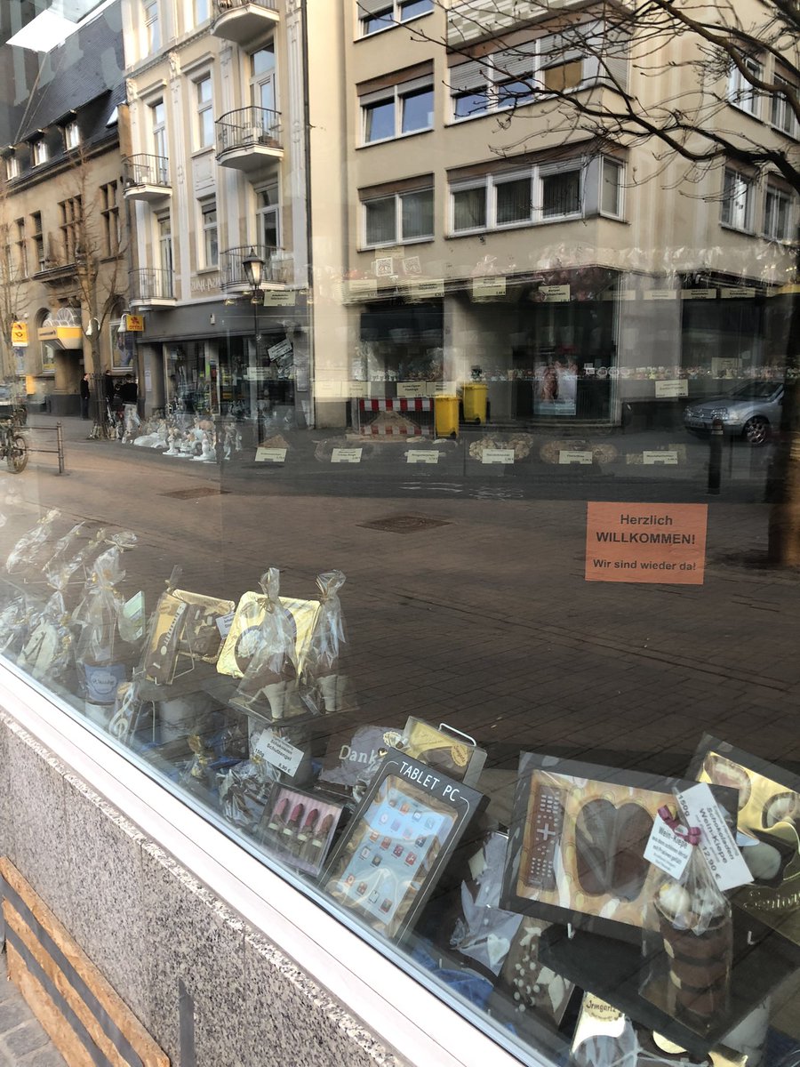 Auslagen im Schokoladen, im Schaufenster spiegelt sich die Hauptstraße.