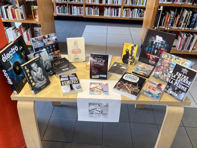 photos de livres et DVD sur la culture HIP-HOP pour accompagner l'exposition de la Philharmonie de Paris sur une table dans la bibliothèque Jules Verne de Pantin