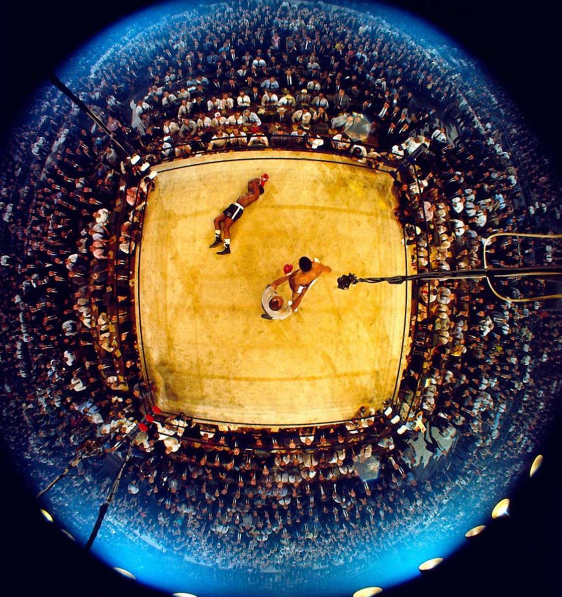 Fisheye lens overhead view of Muhammad Ali knocking out Sonny Liston 

Maine, USA (1965)
