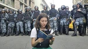 romainejean's tweet photo. Le courage est aussi côté russe. Olga Misik, jeune militante anti-Poutine de 19 ans, opposante à la guerre en #Ukraine , qui manifeste en lisant la constitution russe qui autorise les manifestations pacifistes. Sous le regard de la police qui hésite à intervenir. Image très forte https://t.co/APKG47aphj