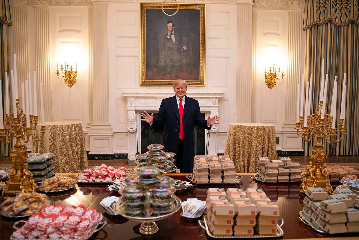 ampol_moment's tweet photo. President Trump posing with over 300 personally bought room temperature burgers for the Clemson Tigers during the government shutdown. (2019) https://t.co/VIIsU4RUaw