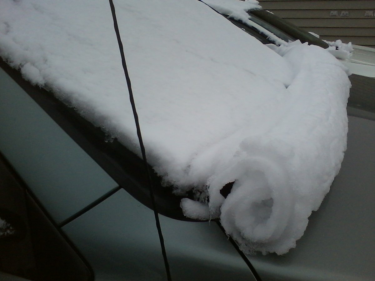 Picture of snow that slid down and formed a perfect roll on my car's windshield.  It looks like a parchment scroll made out of snow.