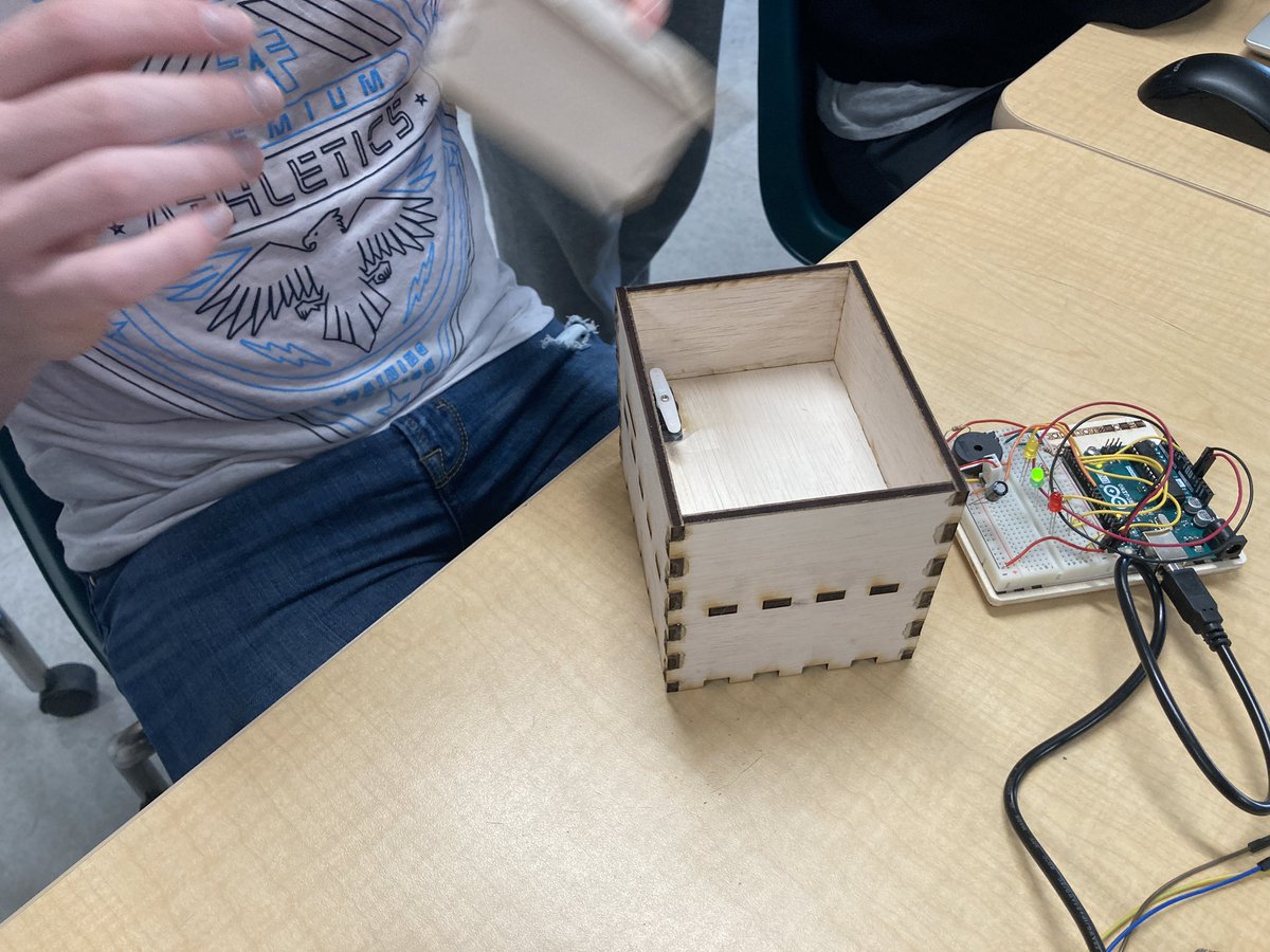NLSD_Huck's tweet photo. Julius explaining his Knock Lock design for the #Intro2Electronics class. This is V3. He is currently making improvements for V4. This is programmed to open the lock based on number and sound of the knocks. Julius designed the box and used an @arduino . https://t.co/6W62QTaYoy