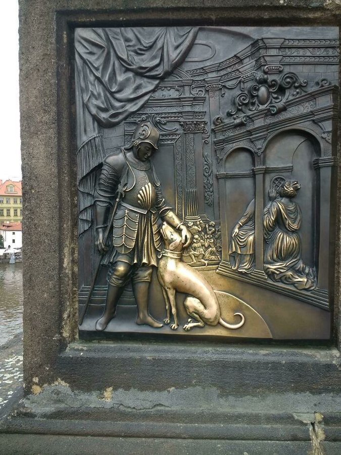 il cane di questo rilievo in bronzo è avvolto in un bagliore dorato perché è stato accarezzato da migliaia di persone per centinaia di anni