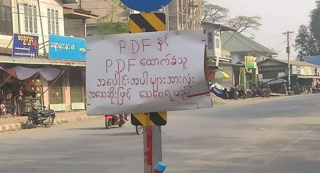 thandarsoesan's tweet photo. Junta threatened that PDF &amp; its supporter will be killed brutally day after PDF-Kalay announced that clashes may erupt in the region.This threatening poster is hanging at the intersection in Kalay. #US_SanctionMOGE  #2022Mar25Coup  #WhatsHappeningInMyanmar https://t.co/7fsHsmUFy3