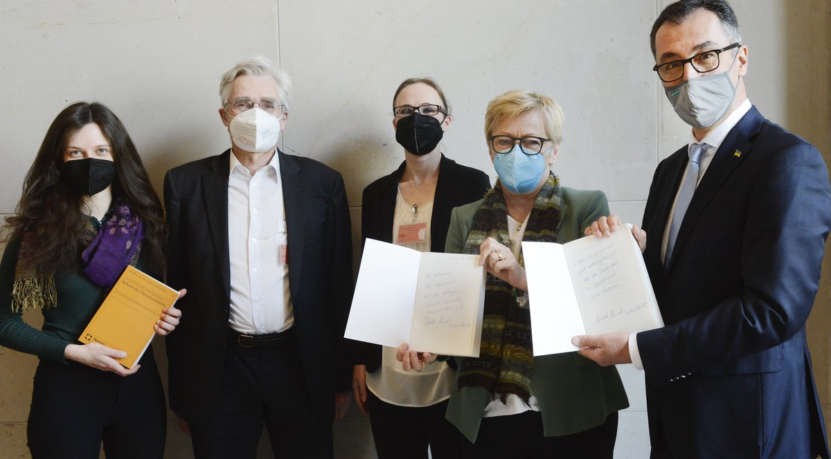 Personengruppe aus fünf Menschen, von links nach rechts: Zoe Mayer, MdB (mit dem orangenen Buch "Reform des Tierschutzgesetzes" in den Händen), Dr. Christoph Maisack und Dr. Barbara Felde (beide Herausgeber*innen des Gutachtens), Renate Künast MdB (mit geöffnetem Buch in der Hand, in der eine Widmung zu erkennen ist) sowie Cem Özdemir Bundesminister für Ernährung und Landwirtschaft (ebenfalls mit geöffnetem Buch in der Hand, ebenfalls mit Widmung)