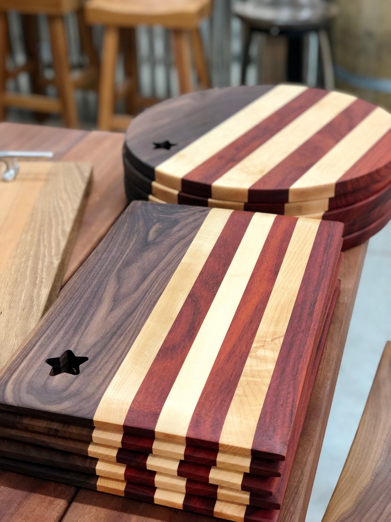 Restocked♥️💙 This fresh batch of American Flag servers is wild with character. Just look at that swirly curly walnut 😍 ⁠
⁠
Order online or stop by the shop to pick out your favorite piece. #woodcharacter #oneofakind #nauticalgifts #starsandstripes