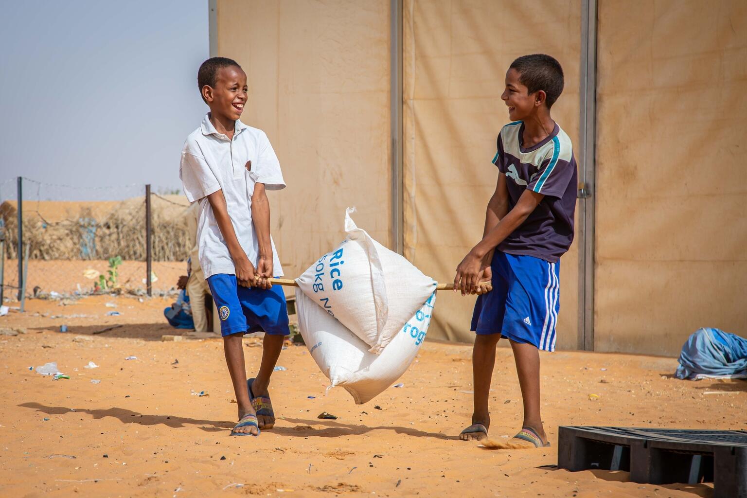 UNICEF Canada on Twitter "Two boys use a stick to transport a bag of