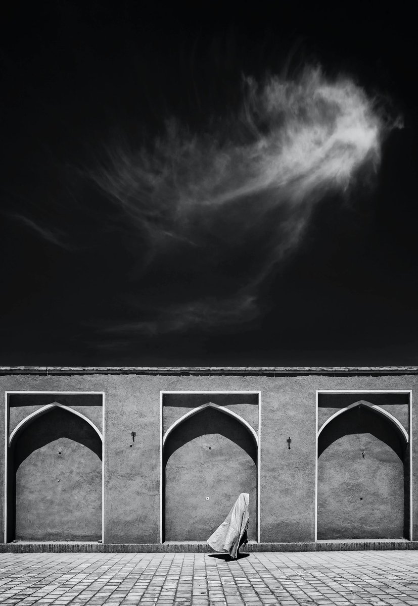 Collected this photo from <a href="/Farshidimages/">Farshid Ahmadpour</a> it’s a beautiful minimalistic composition. The symmetry of the stones beautifully broken by the mysterious woman and the flaky clouds. Who is that woman and where will she go? I love the unknown.