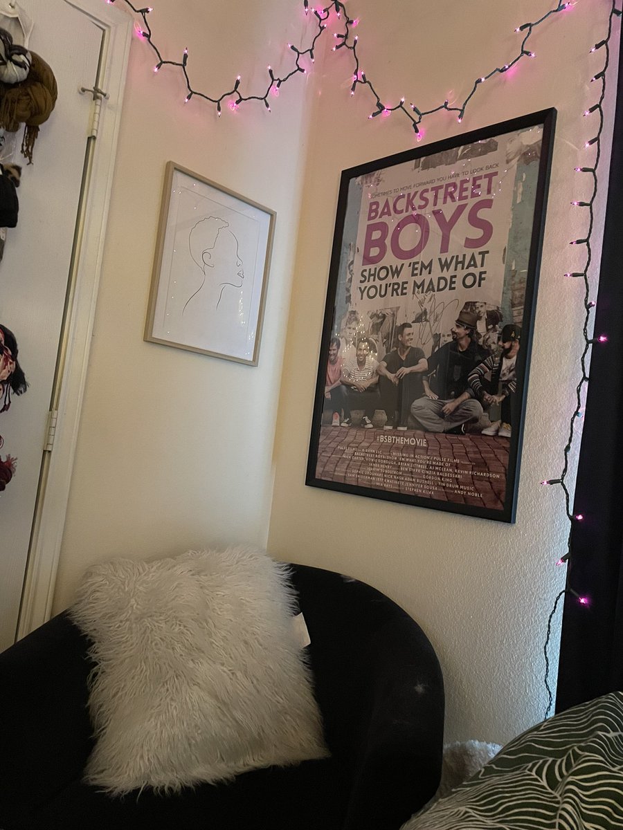 emdanyell's tweet photo. A1/ I have a little reading spot beneath my purple string lights and my treasured Backstreet Boys poster. If I’m not in the chair, I’m usually stretched across my bed! #ReadRChat https://t.co/R5epuDLwCo