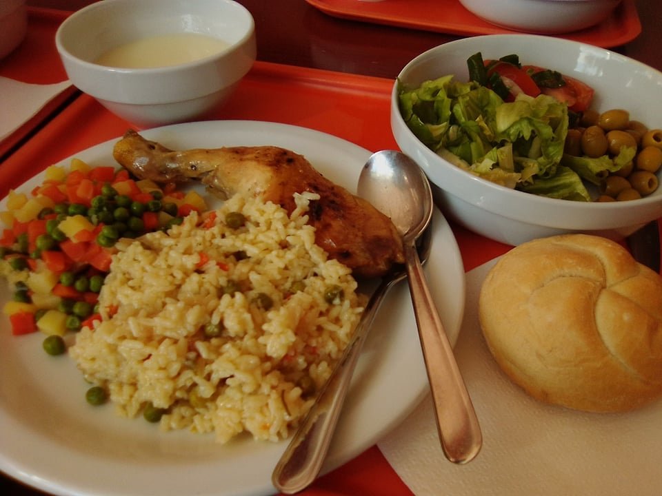 Tablett mit Suppenschale, großes Portion Salat, Teller mit Hähnchenschenkel, Gemüse & Reis, Brötchen. Besteck Chromargan, Geschirr Porzellan.