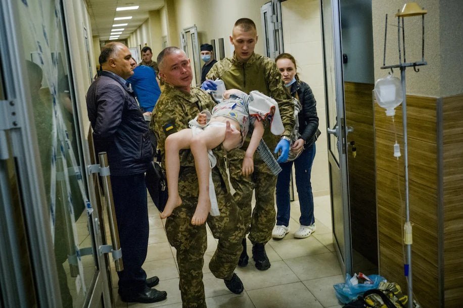 Ukrainian serviceman carrying a child injured by russia's missile strike into a Kramatorsk hospital