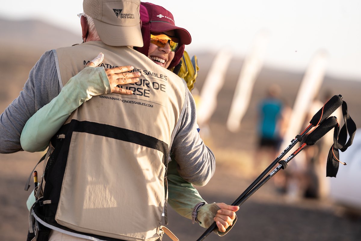 Some incredible photos of me sprinting toward the finish of the #marathondessables and hugging Patrick Bauer, the Directeur de Course, at the end