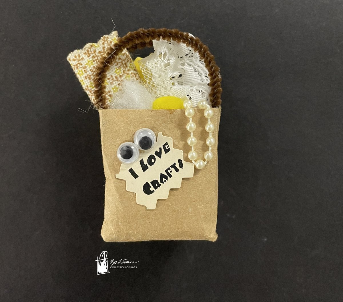 104/365: This friendly miniature magnet bag with its pair of googly eyes and pipe cleaner handle is filled with a mix of craft supplies and a message proclaiming that 'I love crafts.' Adding to its sentiment of crafting joy, the arrangement appears to be handmade. 