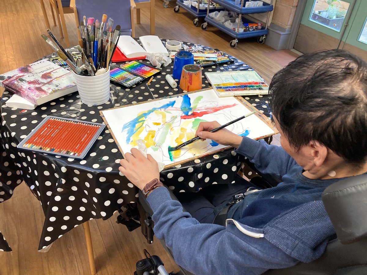 Wah Tan painting during an art session, 2022 Working with artists Belinda Guidi and Maria Doyle, PDRU, Queen Elizabeth University Hospital.