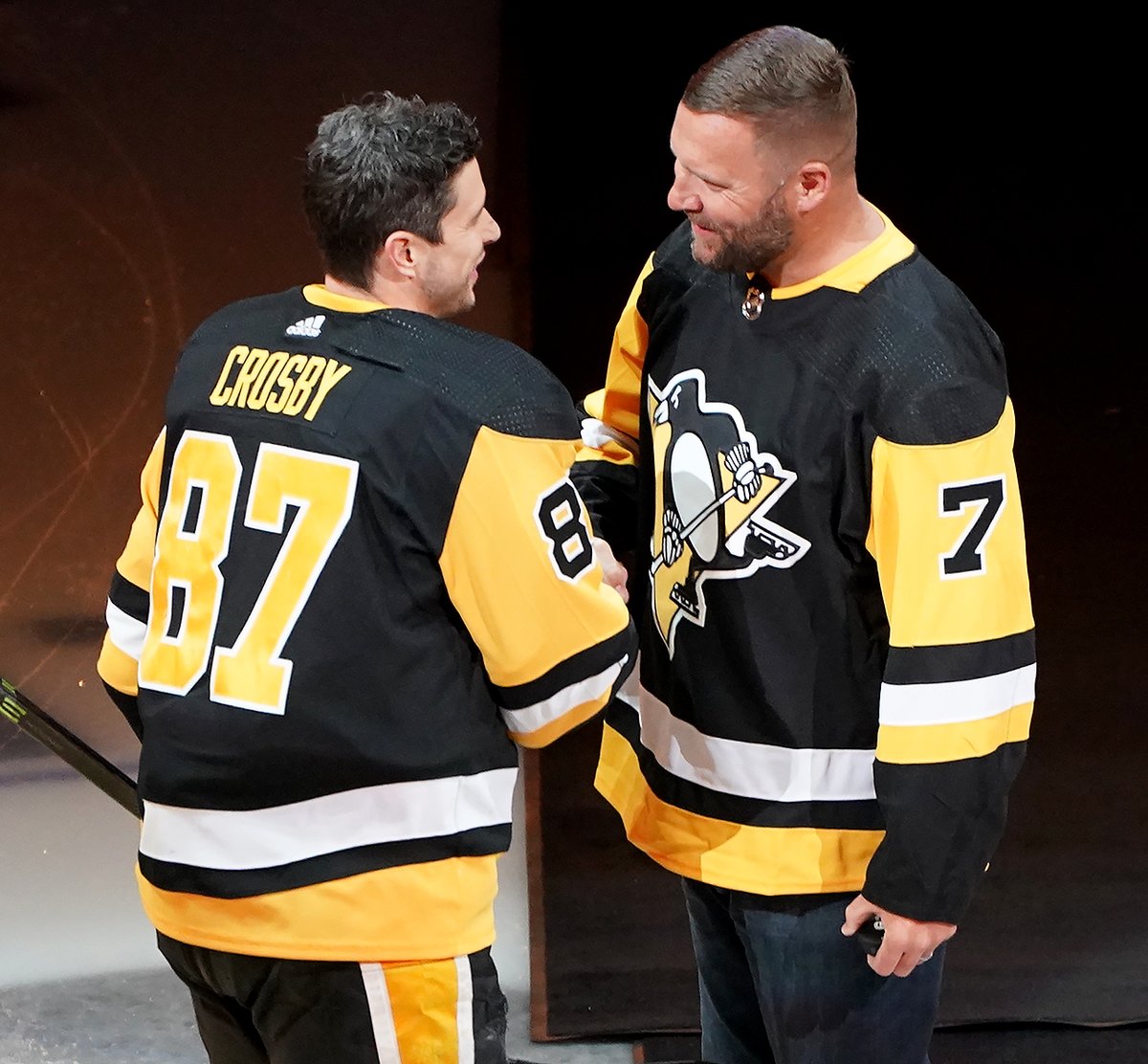 Penguins captain Sidney Crosby shakes hands with retired Steelers quarterback Ben Roethlisberger after after taking part in a ceremonial puck drop before the team takes on the Rangers Tuesday at PPG Paints Arena