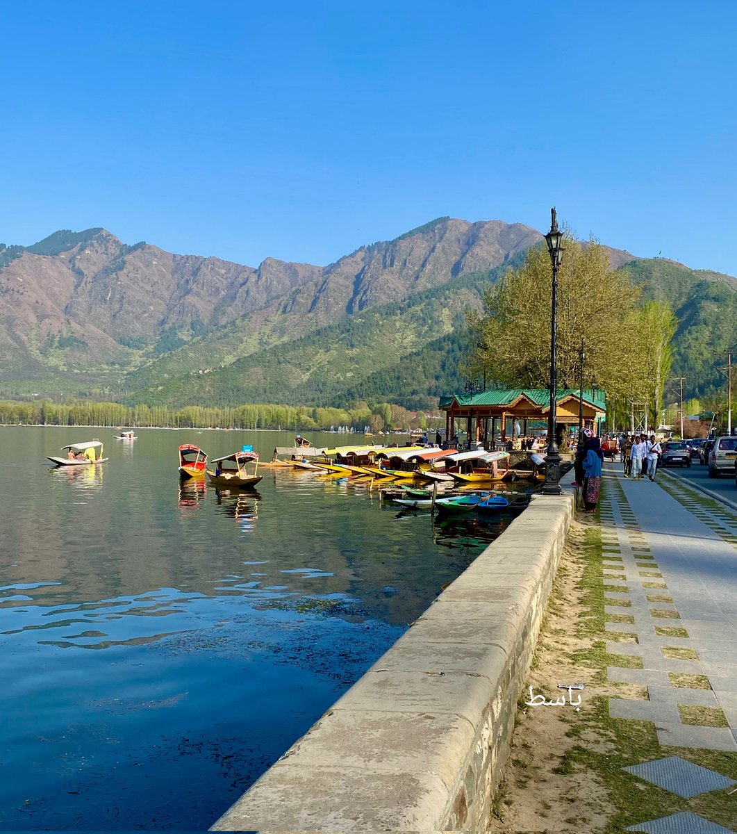basiitzargar's tweet photo. A view of the Dal lake, overlooked by mountains and with shikaras parked along the boulevard road in Srinagar https://t.co/sajVXqqPBa