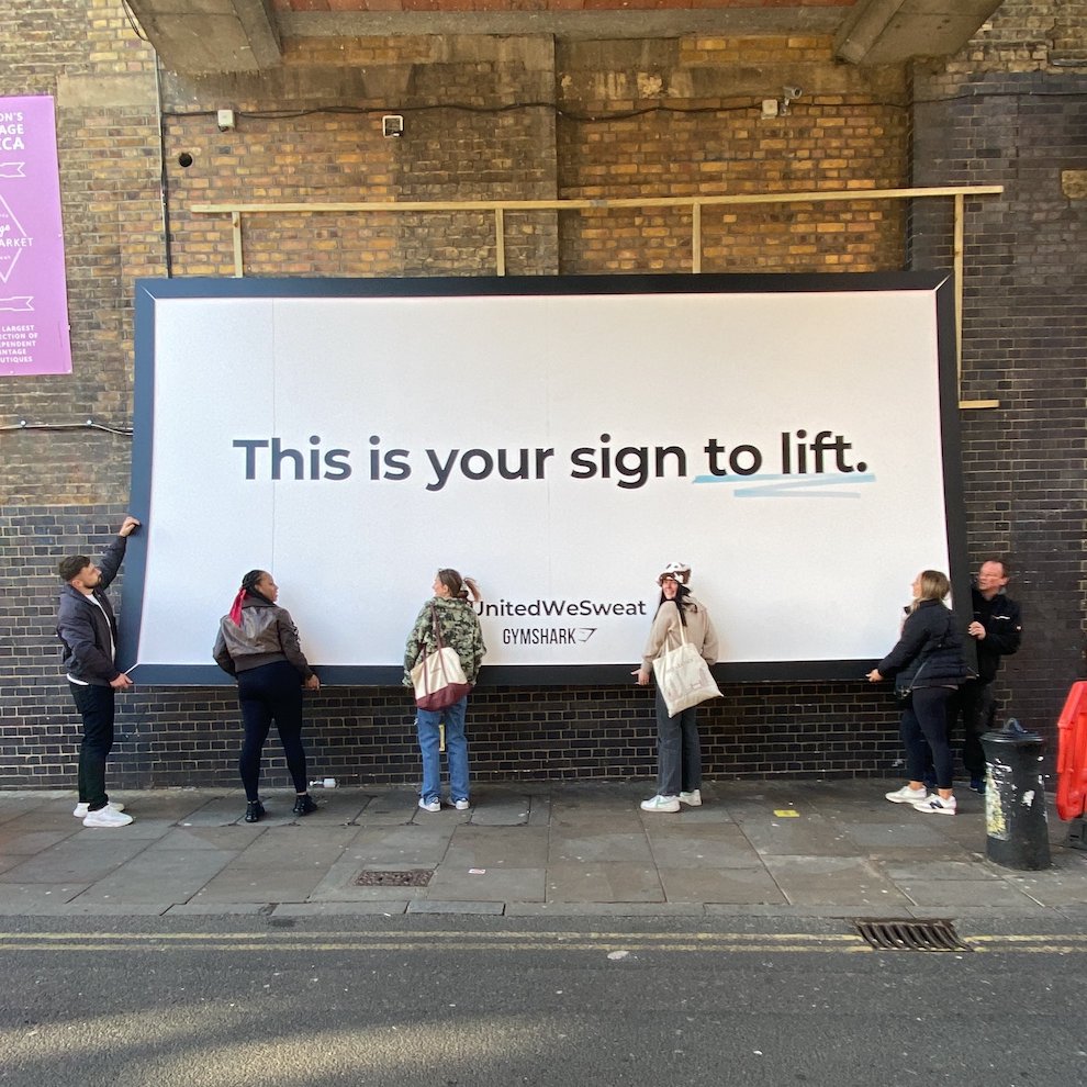 Performance Comms on X: We think Gymshark struck gold with this genius  marketing idea when they had to get the community to physically help lift  their billboard 'because it fell down.' Direct