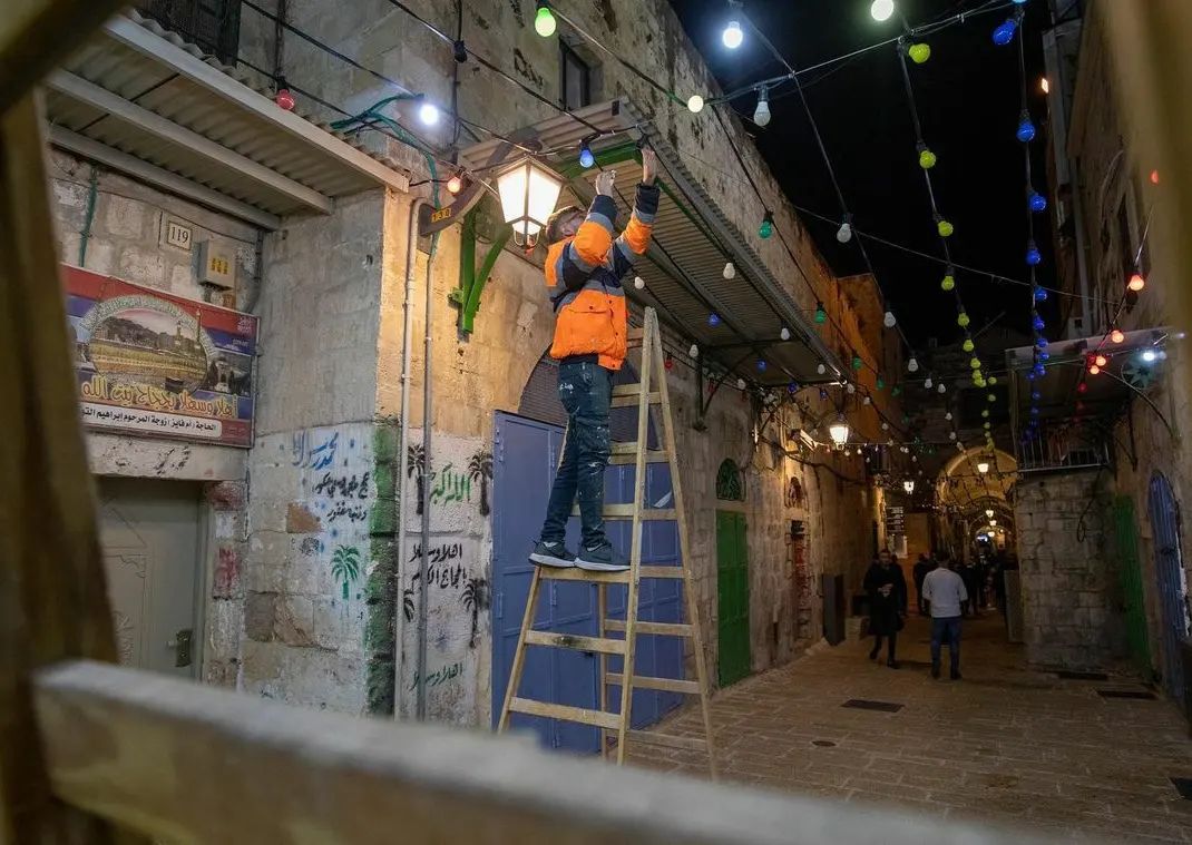 trkudus_en's tweet photo. Palestinians hang Ramadan decorations on the streets in the ancient city.  Despite everything, Ramadan is greeted with enthusiasm in Al-Quds. https://t.co/6TjzWfWwkN