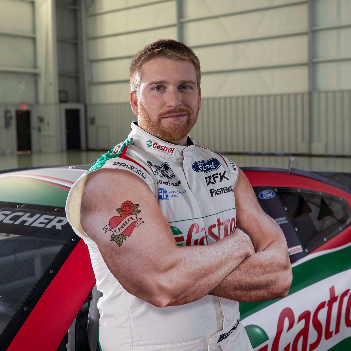 CastrolUSA's tweet photo. It can get pretty hot inside a race car, so this year we’re introducing special summer #firesuits to keep @RFKracing cool. @keselowski what do you think of @chris_buescher new look? #SunsOutGunsOut #ThoseArmsTho https://t.co/WVKTuW8qW7