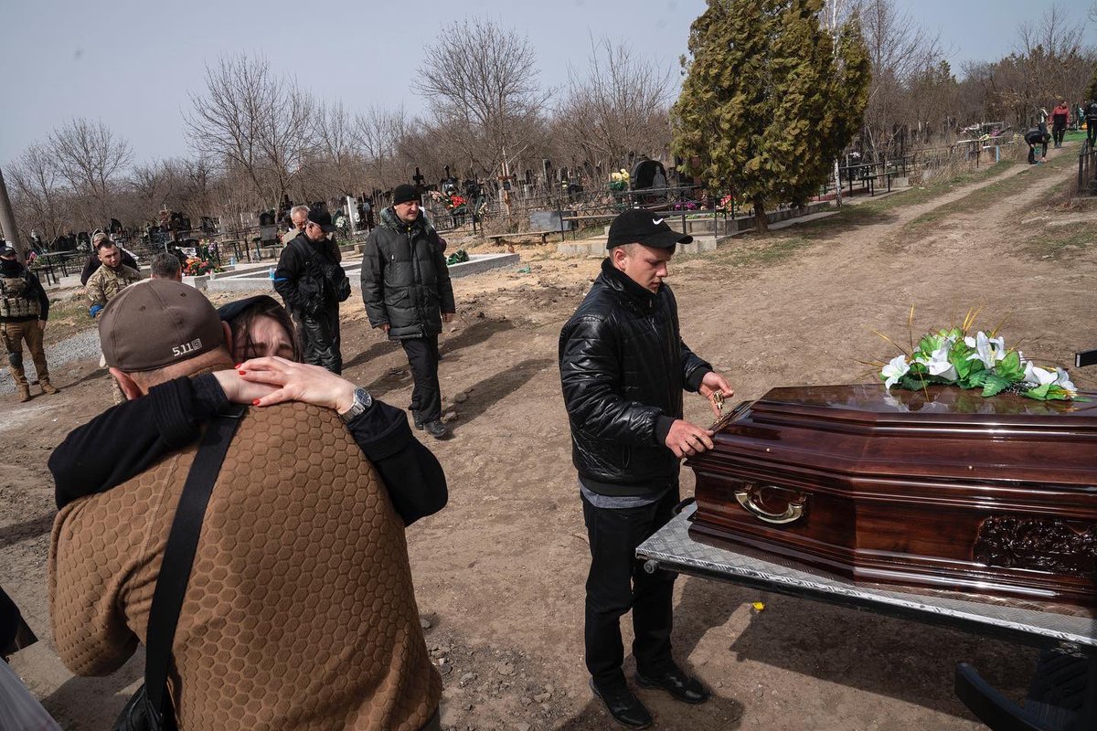 mrchavezphoto's tweet photo. A funeral was held for Andrii Tanulin who was mourned by his family. Tanulin was one of at least 28 killed in a cruise missile attack in Mykolaiv. Dozens are still missing in the rubble of the gov bldng that was hit. #UkraineRussiaWar #photography https://t.co/UCgD7KqdZw