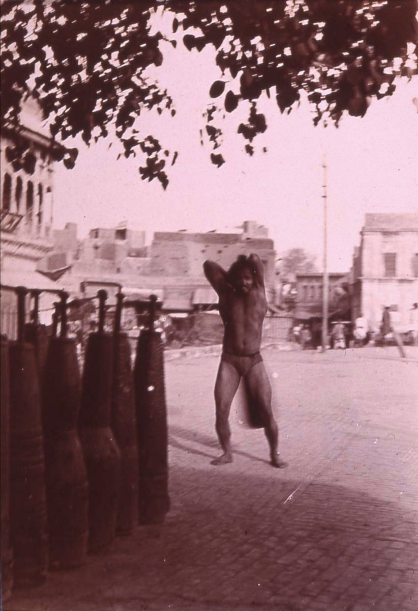 A strongman lifts a mudgar outside the Golden Temple 1905.