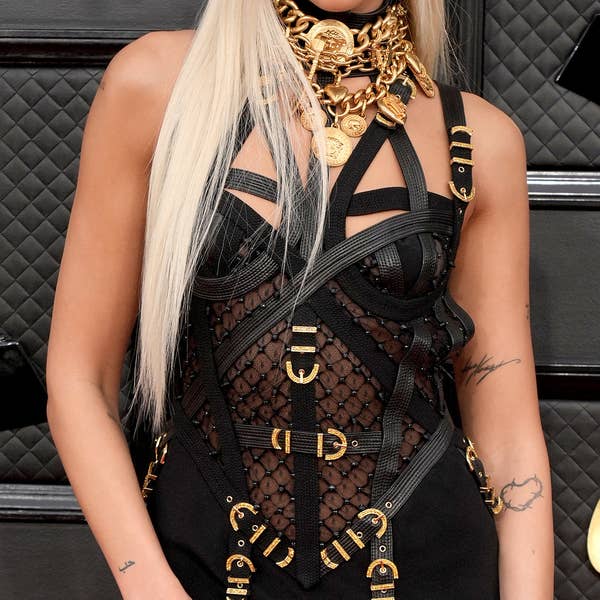Dua Lipa's look is an iconic vintage Versace bondage dress, popularized by  Donatella Versace in the '90s. #GRAMMYs #Grammys2022