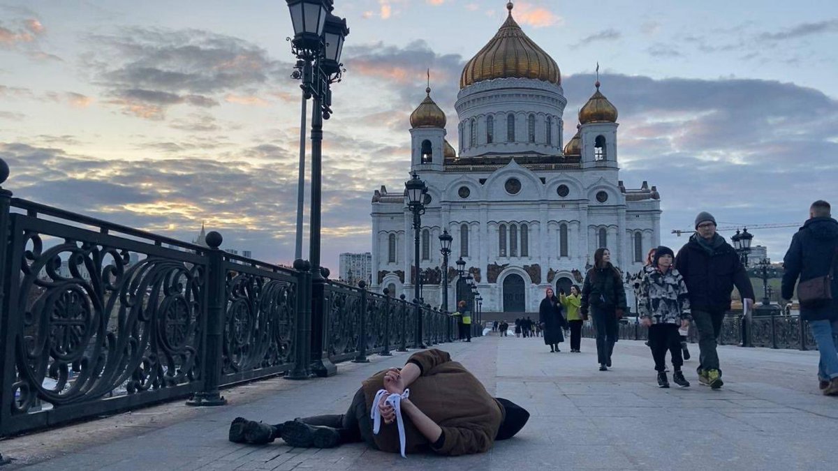 franakviacorka's tweet photo. Dehumanization of society. Many Russians choose not to notice the war in Ukraine, others openly support atrocities. An activist conducted the protest in Moscow downtown: he lay down on the ground with his hands tied behind his back, like victims in Bucha @holodmedia https://t.co/fnJUFrUmTT
