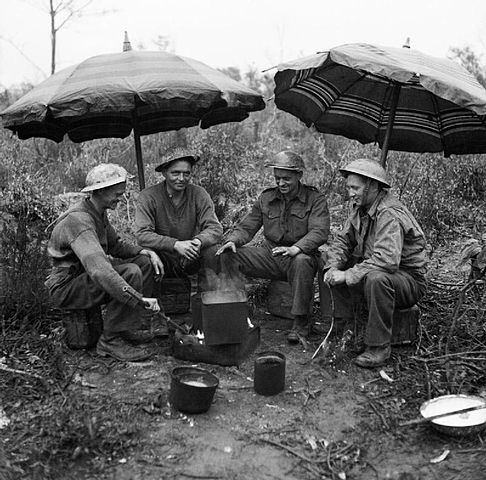 Gunners of the 78th Field Regiment, Royal Artillery make use of two sunshades from a cafe to keep the rain off while making a brew, Anzio, Italy, #otd 27 February 1944.

#Britisharmy #Britishhistory #secondworldwar #royalartillery