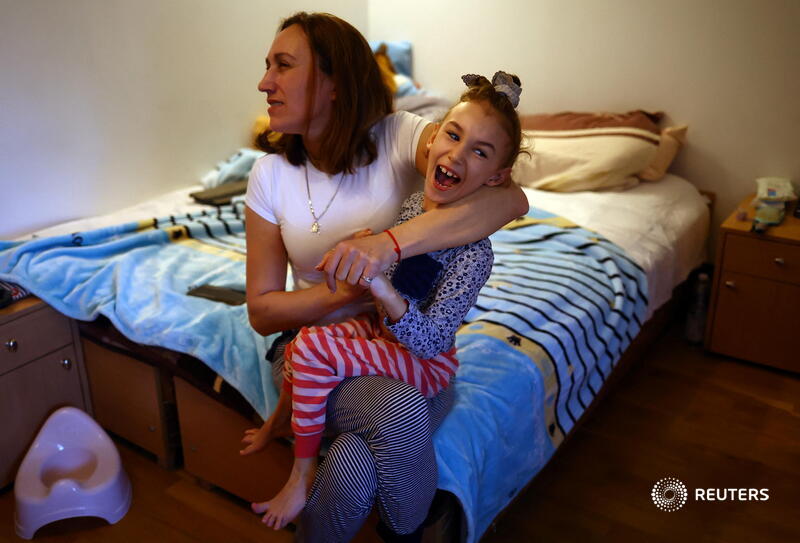 Alevtina is all smiles as she cuddles her mother Alexandra Zhuravel in their bedroom at Poland's Benedictine Sisters Monastery, a world away from Kryvyi Rih in central Ukraine. The eight-year-old has cerebral palsy and cannot speak reut.rs/3j4KuSi via <a href="/hannahmckay88/">Hannah McKay</a> 1/4