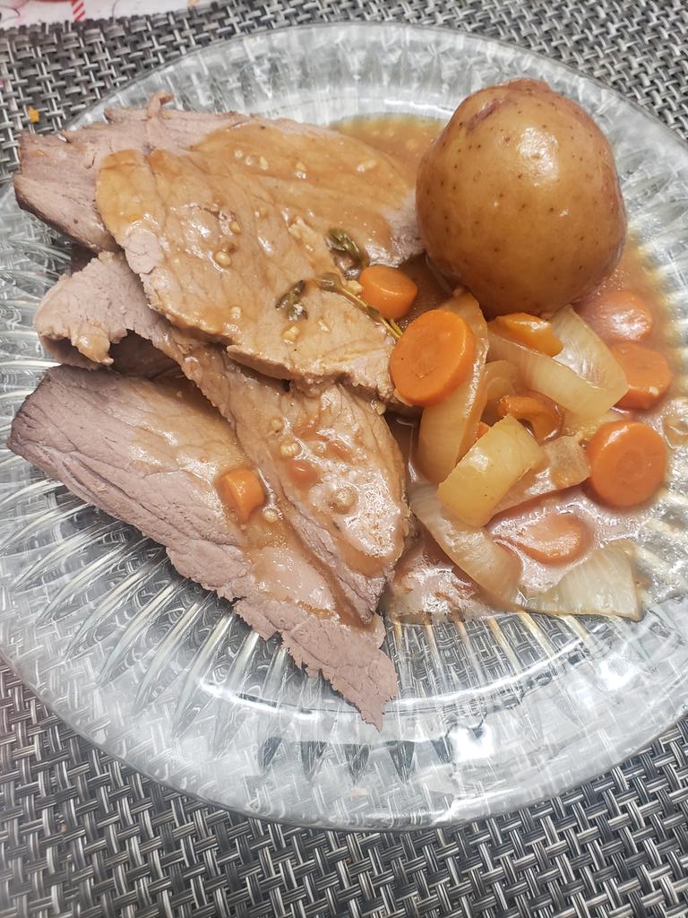 A little slow cooker roast with potatoes onions and carrots in a sauce of red wine,garlic thyme, tomato paste and Worcestshire
