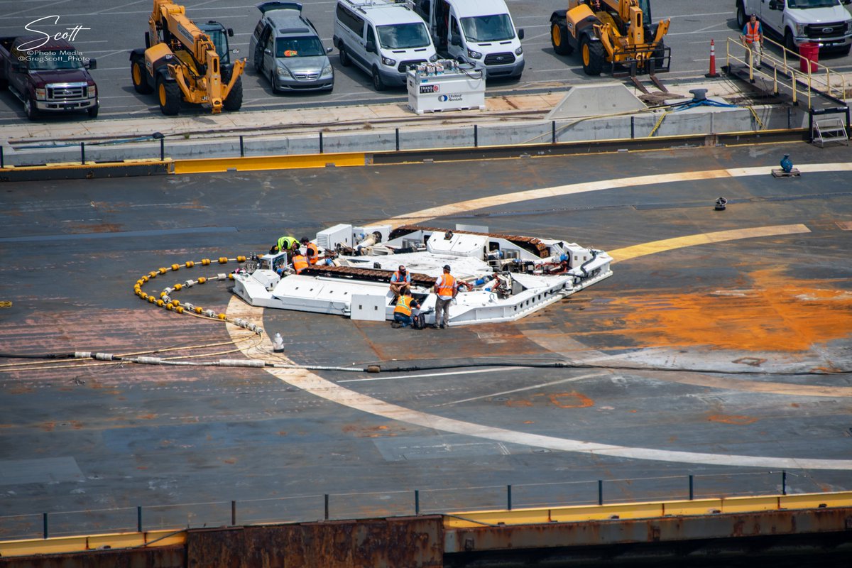 GregScott_photo's tweet photo. On a port flyover yesterday Booster B1061, from the Transporter 4 mission, is hanging from the crane at Port Canaveral waiting to be lowered & transported back to the #SpaceX hanger for refurbishment & reuse. Octagrabber is just getting a little sun🌞#NASA https://t.co/v8809izuHI
