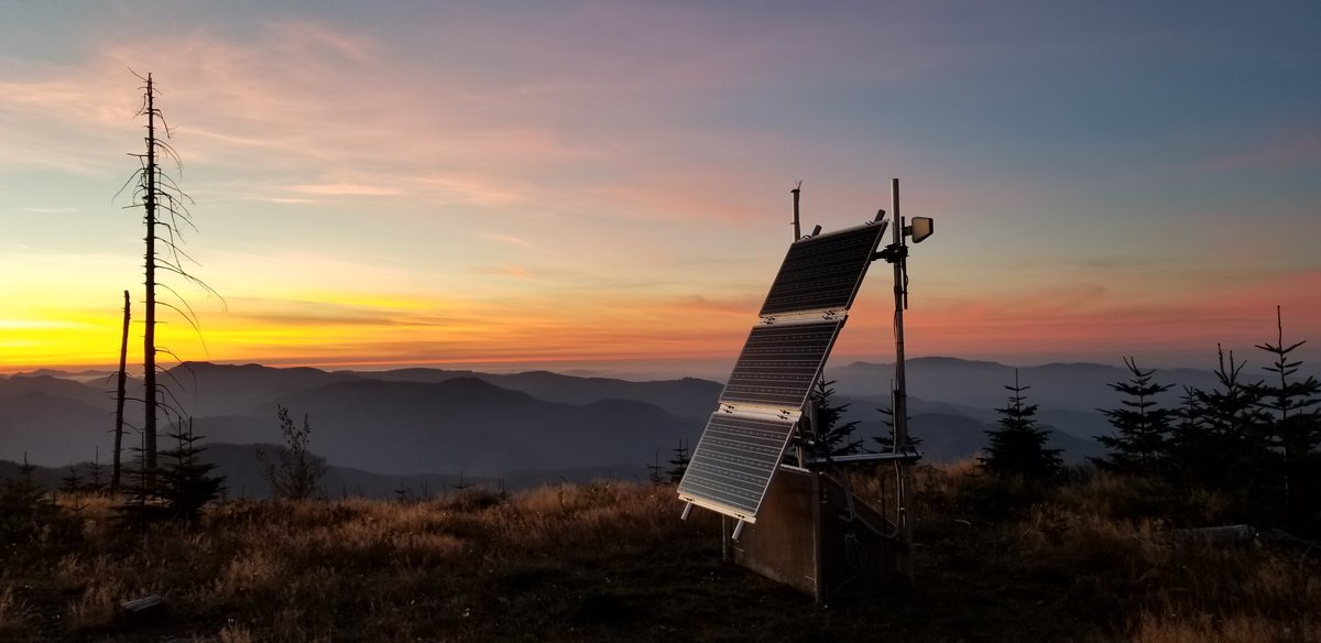 Station BOW2 sits on a mountain ridgetop at sunset. There are layers of mountains in the background.