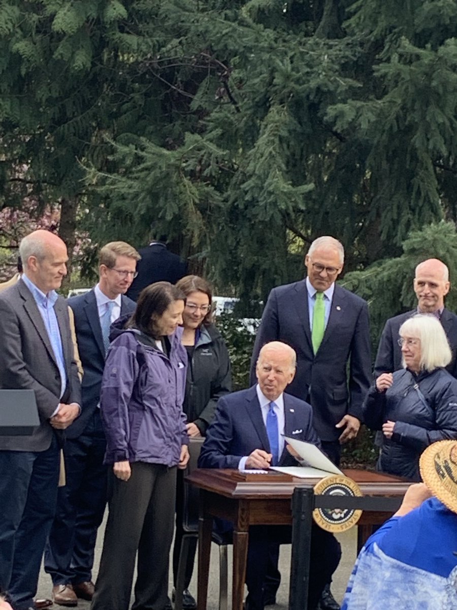 Biden signs executive order. Asks “Is this a state park or a city park?” People call out “city.” Biden hands first pen from signing to Mayor Bruce Harrell.
