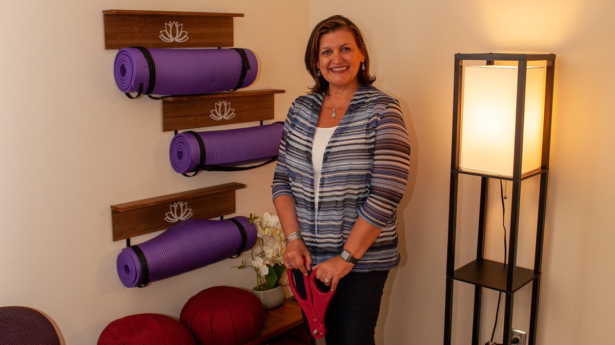 Dr. Pando in the new meditation space with large ceremonial scissors.